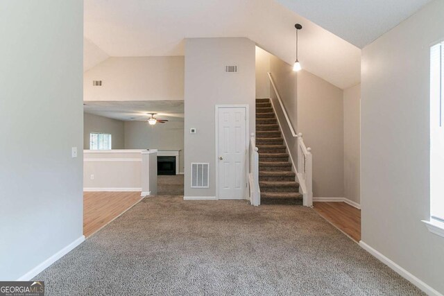 5421 Salem Springs Dr, Lithonia, GA 30038 - unfurnished living room with carpet flooring, stairway, a fireplace, ceiling fan, and high vaulted ceiling