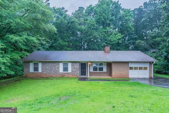 604 Hamlet Ct SE, Conyers, GA 30094 - ranch-style house with an attached garage, asphalt driveway, a chimney, a front lawn, and brick siding