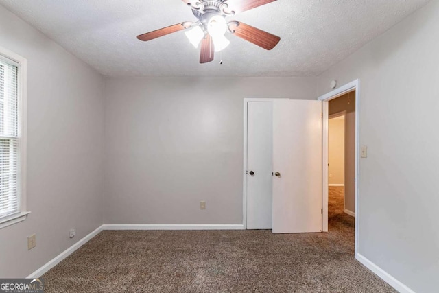 604 Hamlet Ct SE, Conyers, GA 30094 - unfurnished bedroom with carpet flooring, a textured ceiling, baseboards, and a ceiling fan