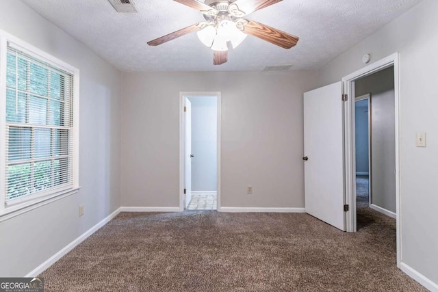 604 Hamlet Ct SE, Conyers, GA 30094 - unfurnished bedroom with carpet flooring, a textured ceiling, baseboards, and ceiling fan