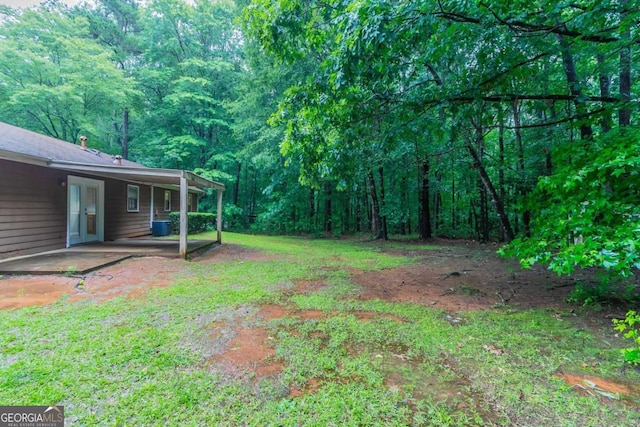 604 Hamlet Ct SE, Conyers, GA 30094 - view of yard with a forest view, a patio area, and central air condition unit