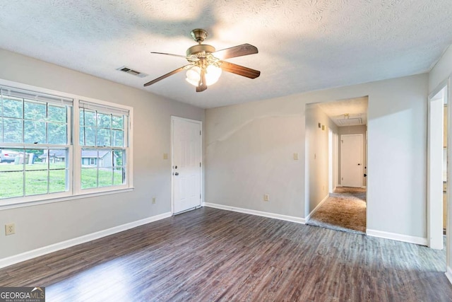 604 Hamlet Ct SE, Conyers, GA 30094 - spare room with attic access, dark wood-type flooring, a ceiling fan, a textured ceiling, and baseboards