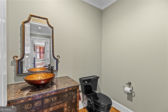 2304 Weeping Oak Dr, Braselton, GA 30517 - half bath featuring crown molding, toilet, vanity, wood finished floors, and baseboards