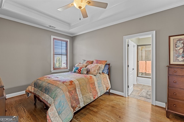 2304 Weeping Oak Dr, Braselton, GA 30517 - bedroom with wood finished floors, a tray ceiling, ornamental molding, baseboards, and ensuite bath