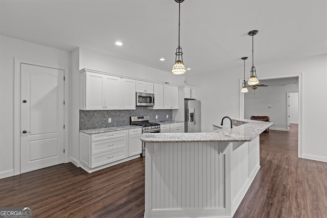 2304 Weeping Oak Dr, Braselton, GA 30517 - kitchen featuring stainless steel appliances, dark wood-style flooring, white cabinetry, backsplash, and recessed lighting