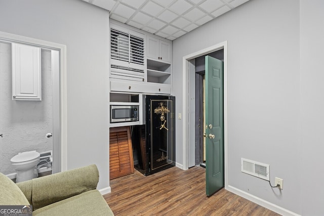 2304 Weeping Oak Dr, Braselton, GA 30517 - kitchen featuring wood finished floors, stainless steel microwave, baseboards, and white cabinetry