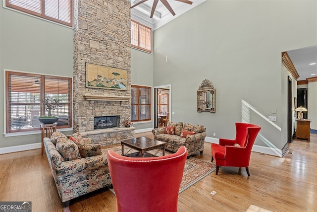 2304 Weeping Oak Dr, Braselton, GA 30517 - living area featuring a towering ceiling, baseboards, plenty of natural light, a ceiling fan, and a fireplace
