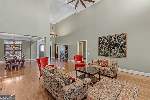 2304 Weeping Oak Dr, Braselton, GA 30517 - living room featuring ornamental molding, a chandelier, baseboards, wood finished floors, and a ceiling fan