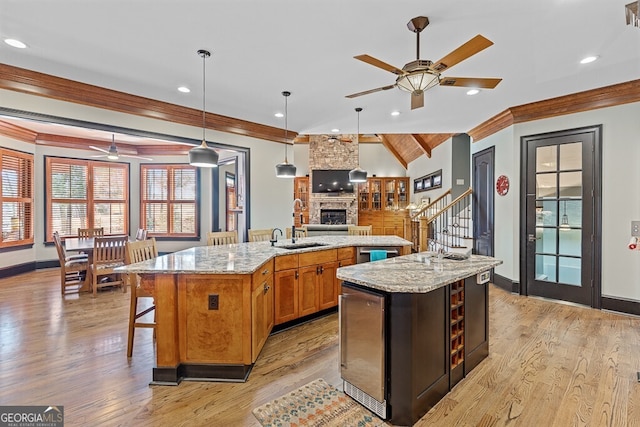 2304 Weeping Oak Dr, Braselton, GA 30517 - kitchen featuring ceiling fan, a large island, a fireplace, open floor plan, and ornamental molding