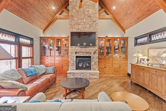 2304 Weeping Oak Dr, Braselton, GA 30517 - living room with high vaulted ceiling, wood finished floors, a stone fireplace, wood ceiling with exposed beams, and baseboards