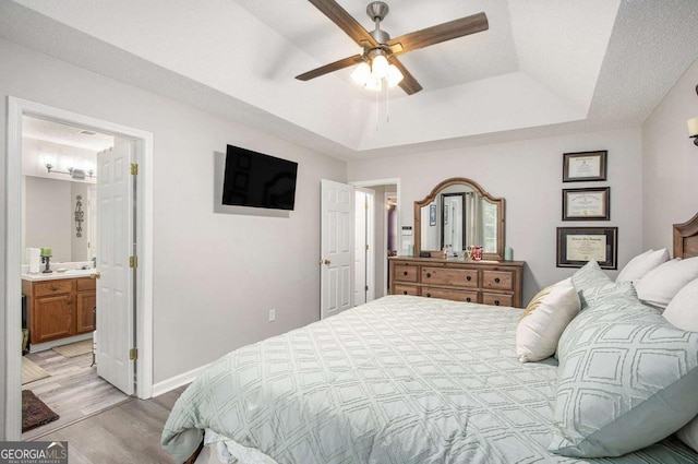 169 Winding Valley Dr, Rockmart, GA 30153 - bedroom featuring light wood-type flooring, a tray ceiling, and ceiling fan