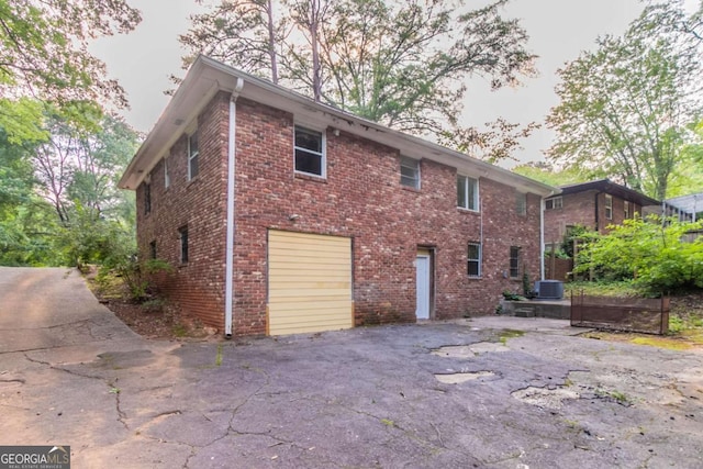 2582 Springdale Rd SW, Atlanta, GA 30315 - view of side of home featuring a garage, asphalt driveway, central AC, and brick siding