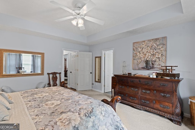 320 Cobb Ct, Hampton, GA 30228 - bedroom featuring light carpet, baseboards, a tray ceiling, and a ceiling fan