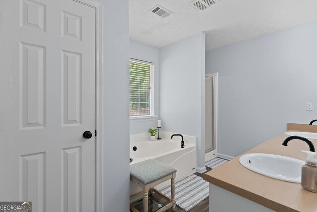 320 Cobb Ct, Hampton, GA 30228 - full bathroom featuring a garden tub, a stall shower, double vanity, baseboards, and wood finished floors