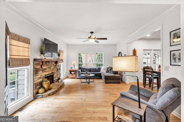 1637 Willow Way, Woodstock, GA 30188 - living area with a ceiling fan, light wood finished floors, crown molding, a stone fireplace, and baseboards