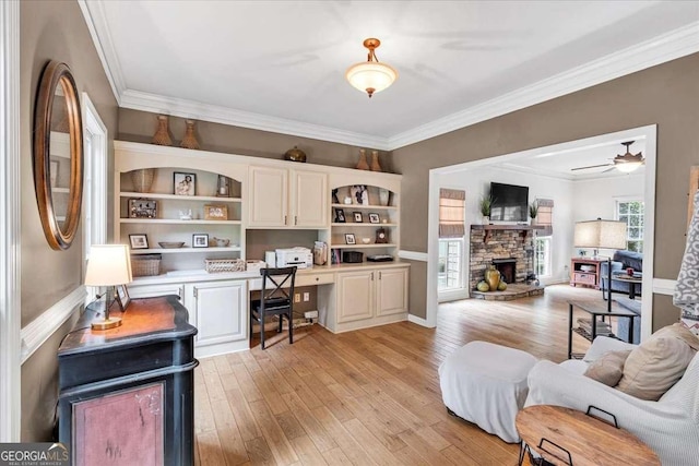 1637 Willow Way, Woodstock, GA 30188 - office area featuring built in desk, light wood-type flooring, ornamental molding, a stone fireplace, and a ceiling fan