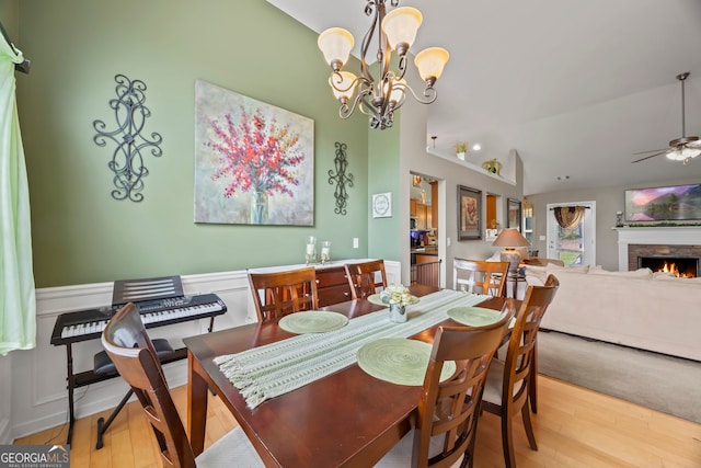 5511 Preserve Pt, Flowery Branch, GA 30542 - dining room with wood finished floors, a ceiling fan, a wainscoted wall, a stone fireplace, and a chandelier