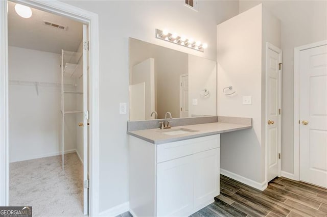 7006 Mahonia Pl, Lithonia, GA 30038 - bathroom featuring vanity, wood finished floors, baseboards, and a walk in closet