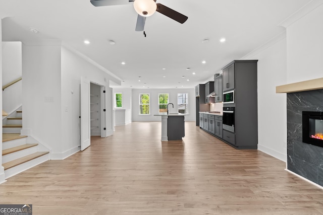 586 Avondale Park Cir Unit 51, Decatur, GA 30032 - kitchen featuring open floor plan, ornamental molding, a center island with sink, black oven, and a ceiling fan