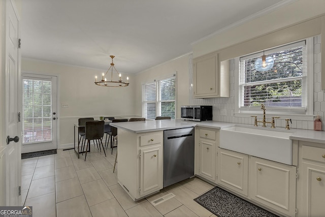2715 N Doublegate Dr, Albany, GA 31721 - kitchen with appliances with stainless steel finishes, a chandelier, a peninsula, light countertops, and light tile patterned flooring