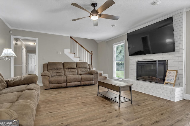 2715 N Doublegate Dr, Albany, GA 31721 - living area with a ceiling fan, wood finished floors, crown molding, a fireplace, and stairs