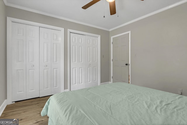 2715 N Doublegate Dr, Albany, GA 31721 - bedroom featuring two closets, wood finished floors, ornamental molding, and a ceiling fan