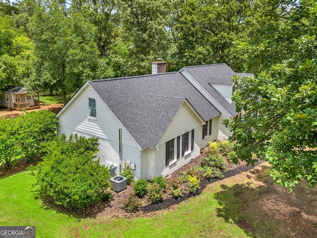 2715 N Doublegate Dr, Albany, GA 31721 - view of property exterior with a shingled roof, a chimney, brick siding, a lawn, and view of wooded area