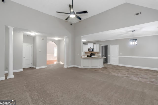 185 Stewart Glen Dr, Covington, GA 30014 - unfurnished living room with carpet flooring, a ceiling fan, arched walkways, baseboards, and high vaulted ceiling