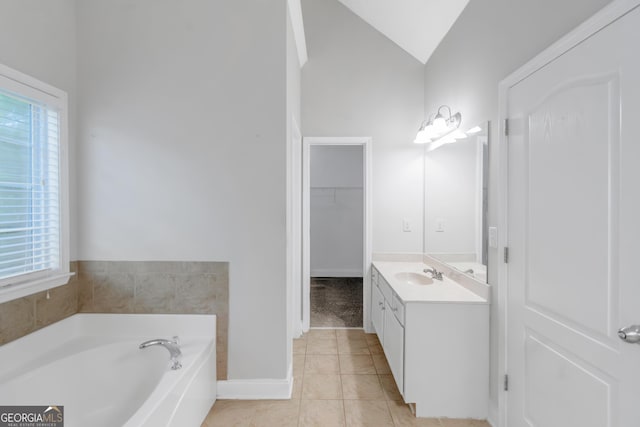 185 Stewart Glen Dr, Covington, GA 30014 - full bathroom with vanity, a garden tub, vaulted ceiling, tile patterned floors, and a spacious closet
