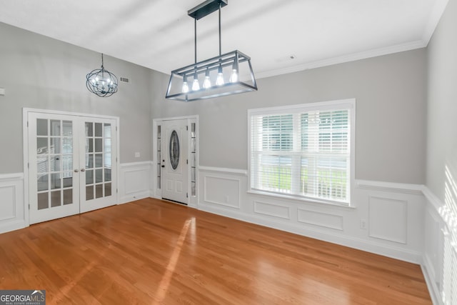 185 Stewart Glen Dr, Covington, GA 30014 - entrance foyer with a chandelier, french doors, wood finished floors, a wainscoted wall, and a decorative wall