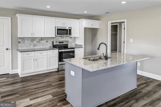 204 Eric Cv, Byron, GA 31008 - kitchen featuring appliances with stainless steel finishes, a sink, white cabinets, dark wood-type flooring, and light stone counters
