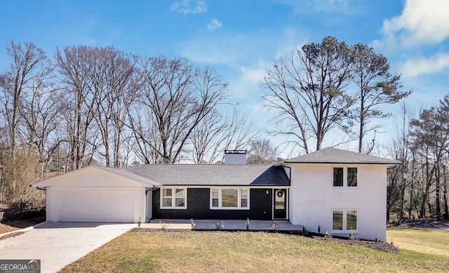 1536 Daffodil Dr, Marietta, GA 30062 - split level home with an attached garage, concrete driveway, a chimney, a front lawn, and brick siding