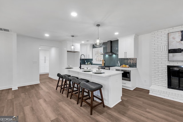1536 Daffodil Dr, Marietta, GA 30062 - kitchen with wall chimney exhaust hood, stainless steel microwave, light countertops, white cabinetry, and a breakfast bar