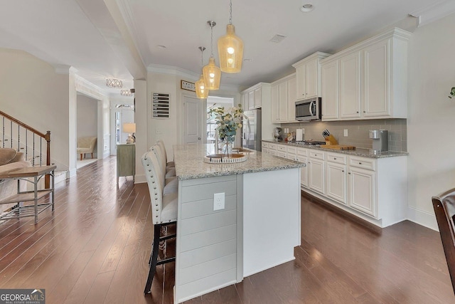 406 Fernstone Dr, Canton, GA 30114 - kitchen with stainless steel appliances, a breakfast bar, dark wood-style floors, decorative backsplash, and light stone countertops