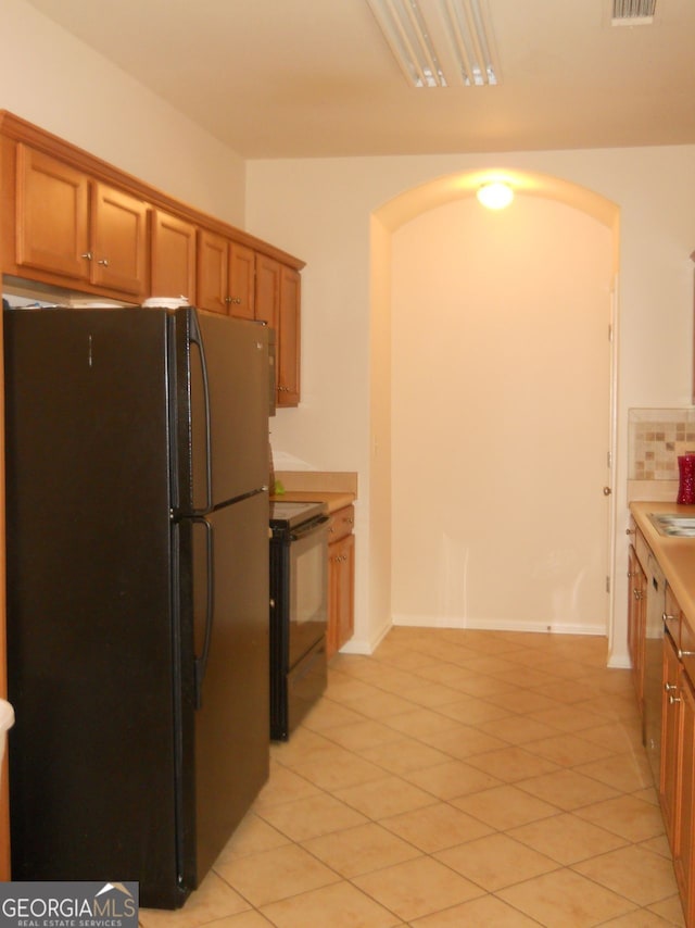 4750 Crinklepoint Ct, Douglasville, GA 30134 - kitchen featuring black appliances, arched walkways, brown cabinets, and light tile patterned flooring