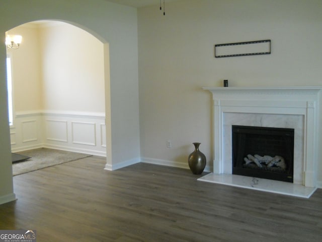 4750 Crinklepoint Ct, Douglasville, GA 30134 - unfurnished living room featuring wood finished floors, arched walkways, a fireplace, and wainscoting