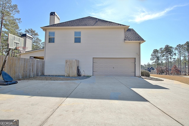 201 Fox Hall Xing E, Senoia, GA 30276 - view of side of home featuring concrete driveway, a garage, a shingled roof, and a chimney