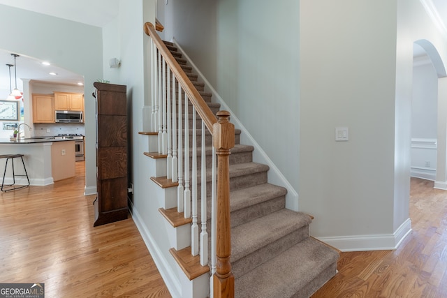 300 Brackin Trce, Grayson, GA 30017 - stairs with wood finished floors, arched walkways, and recessed lighting