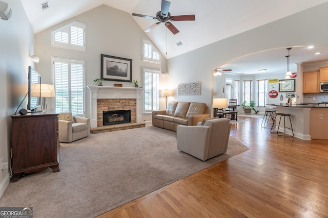 300 Brackin Trce, Grayson, GA 30017 - living area featuring ceiling fan, light wood finished floors, healthy amount of natural light, a stone fireplace, and high vaulted ceiling