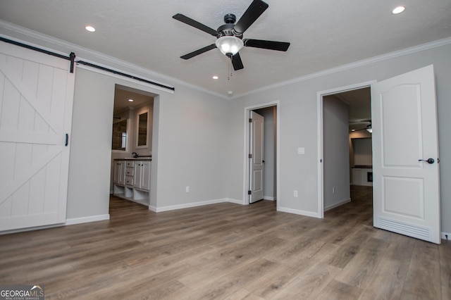 74 Preacher Smith Rd SE, Silver Creek, GA 30173 - unfurnished bedroom featuring wood finished floors, ornamental molding, baseboards, recessed lighting, and a barn door