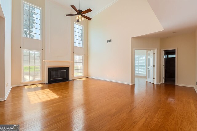 1713 Paramore Pl NE, Marietta, GA 30062 - unfurnished living room featuring high vaulted ceiling, ceiling fan, healthy amount of natural light, and crown molding
