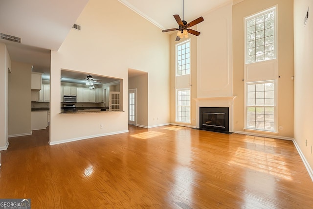 1713 Paramore Pl NE, Marietta, GA 30062 - unfurnished living room with a ceiling fan, a high ceiling, plenty of natural light, light wood finished floors, and ornamental molding