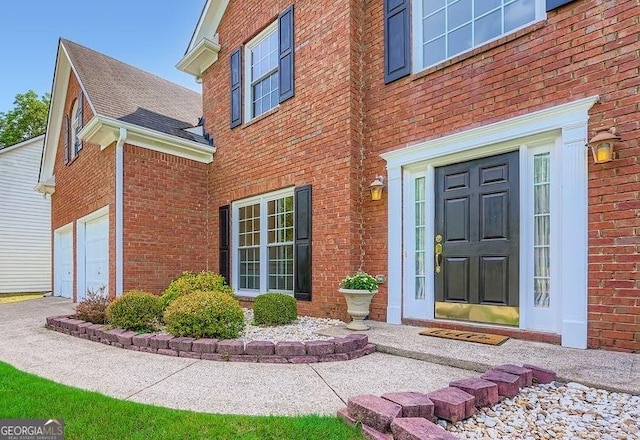 1713 Paramore Pl NE, Marietta, GA 30062 - doorway to property with brick siding, an attached garage, driveway, and a shingled roof