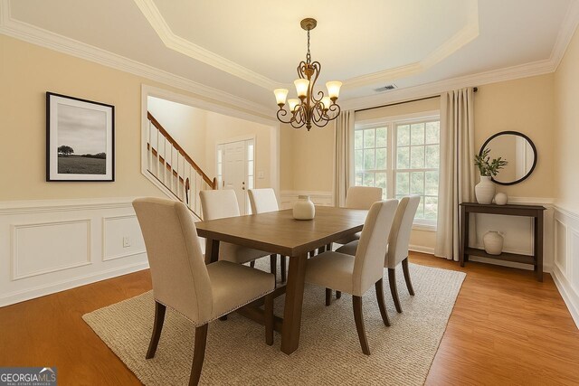 1713 Paramore Pl NE, Marietta, GA 30062 - dining space with ornamental molding, a tray ceiling, a chandelier, wainscoting, and light wood finished floors