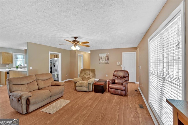 11 Chestnut St, Cartersville, GA 30120 - living area with light wood-style floors, baseboards, a ceiling fan, and a textured ceiling