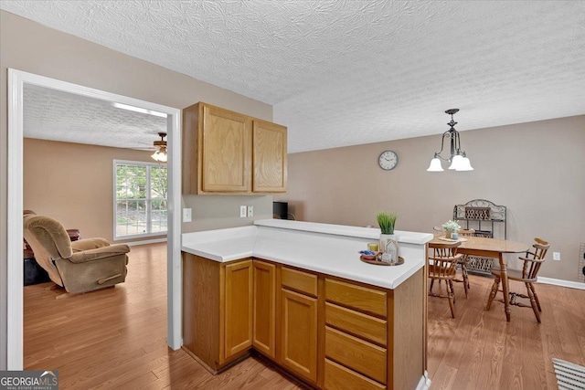 11 Chestnut St, Cartersville, GA 30120 - kitchen with a textured ceiling, light wood finished floors, light countertops, a peninsula, and ceiling fan