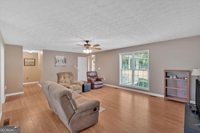 11 Chestnut St, Cartersville, GA 30120 - living area featuring baseboards, light wood-style floors, a ceiling fan, and a textured ceiling