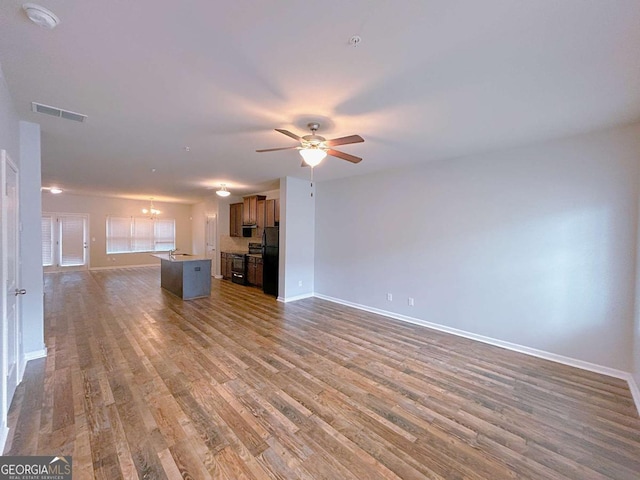 1531 Iris Walk, Jonesboro, GA 30238 - unfurnished living room featuring baseboards, wood finished floors, ceiling fan, and a chandelier