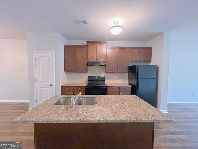1531 Iris Walk, Jonesboro, GA 30238 - kitchen featuring black appliances, a sink, under cabinet range hood, baseboards, and wood finished floors