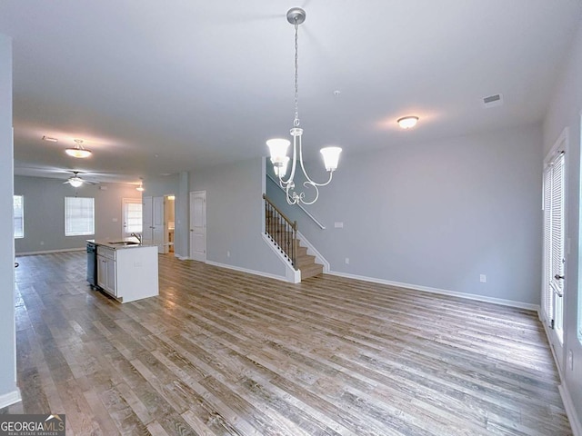 1892 Old Dogwood, Jonesboro, GA 30238 - unfurnished living room featuring a sink, wood finished floors, baseboards, stairs, and a chandelier